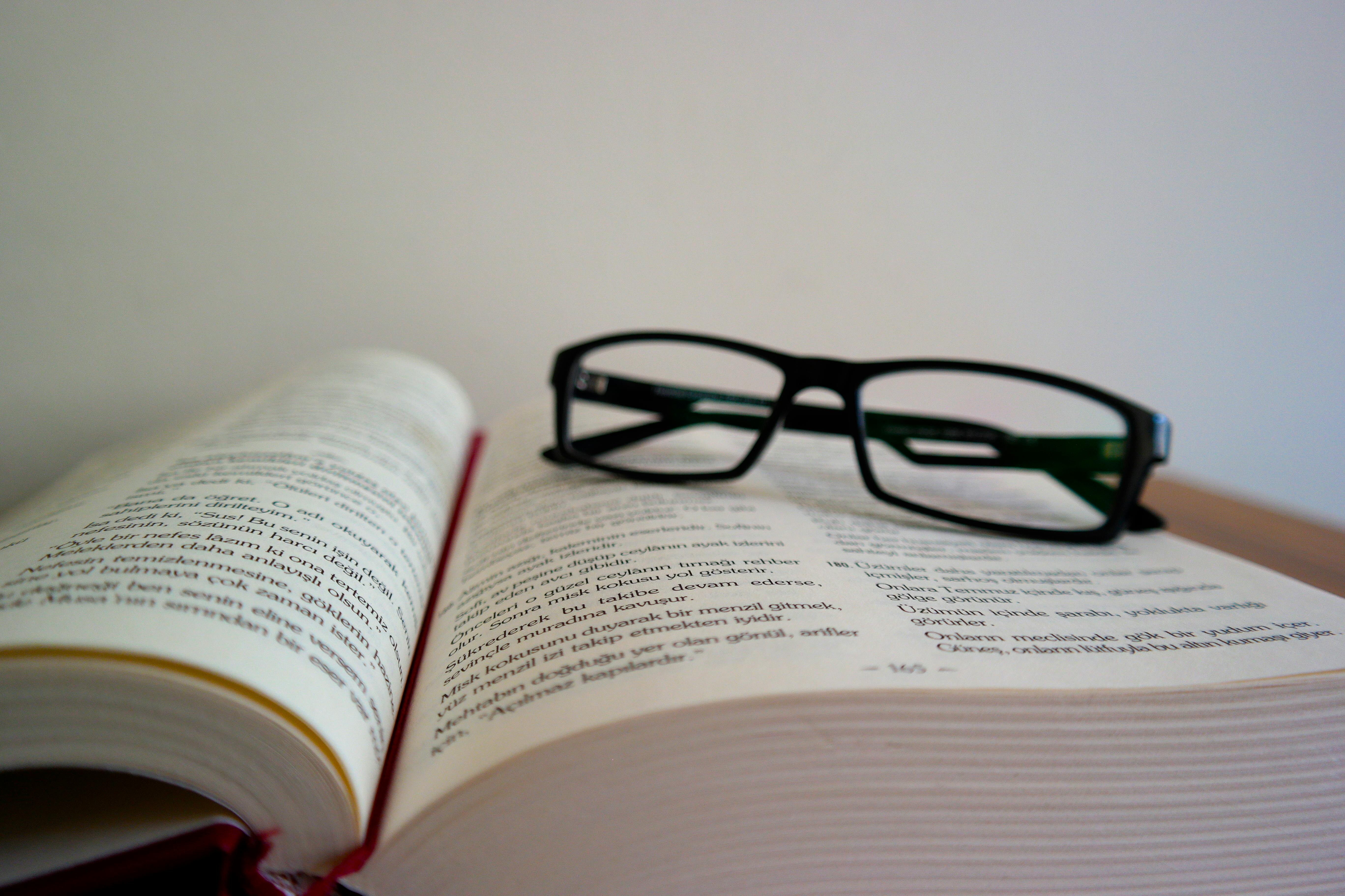 black glasses on an open book